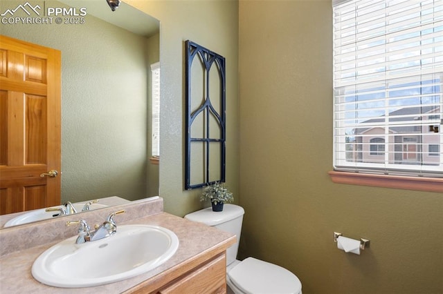 11985 Hanging Valley Way, Colorado Springs, CO 80921 - bathroom with toilet, healthy amount of natural light, vanity, and a textured wall