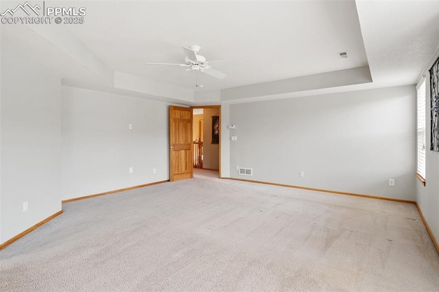11985 Hanging Valley Way, Colorado Springs, CO 80921 - spare room with a tray ceiling, ceiling fan, baseboards, and light colored carpet