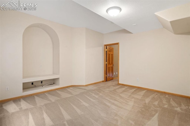 11985 Hanging Valley Way, Colorado Springs, CO 80921 - carpeted empty room featuring baseboards, built in features, and arched walkways