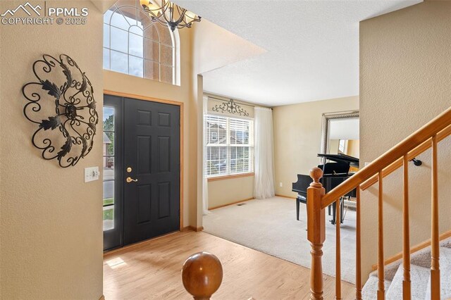11985 Hanging Valley Way, Colorado Springs, CO 80921 - foyer featuring wood finished floors, stairway, baseboards, a textured wall, and a chandelier