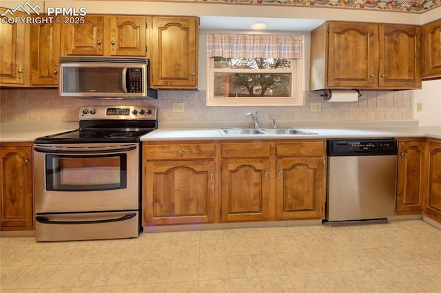 770 Allegheny Dr, Colorado Springs, CO 80919 - kitchen with appliances with stainless steel finishes, a sink, brown cabinets, light countertops, and backsplash