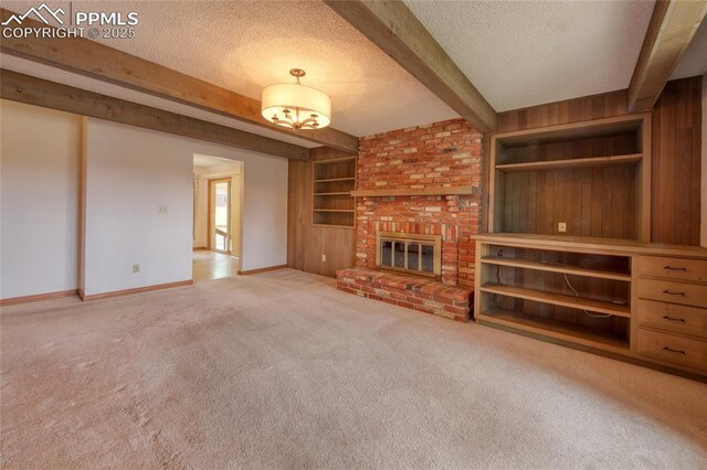 770 Allegheny Dr, Colorado Springs, CO 80919 - unfurnished living room featuring a textured ceiling, carpet floors, beamed ceiling, baseboards, and built in features