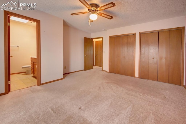 770 Allegheny Dr, Colorado Springs, CO 80919 - unfurnished bedroom with light carpet, two closets, connected bathroom, a textured ceiling, and baseboards