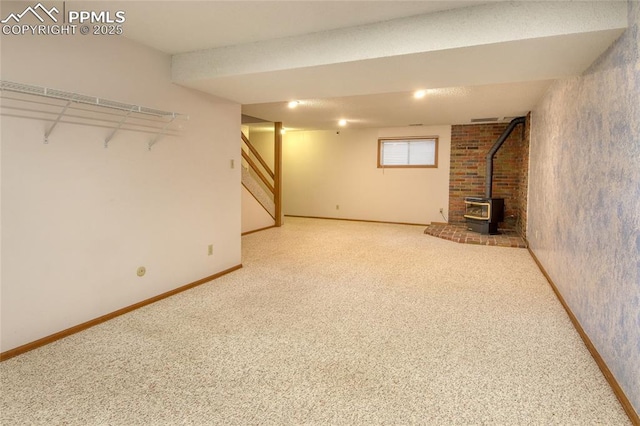 770 Allegheny Dr, Colorado Springs, CO 80919 - below grade area featuring a wood stove, carpet flooring, stairs, and baseboards