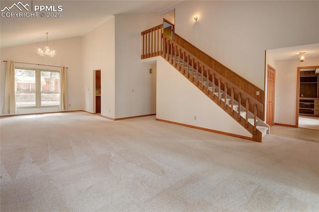 770 Allegheny Dr, Colorado Springs, CO 80919 - unfurnished living room with carpet floors, a chandelier, stairs, high vaulted ceiling, and baseboards