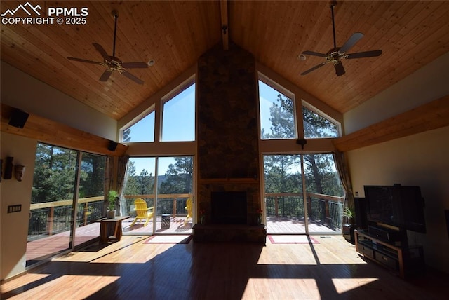 78 Powderhorn Ln, Florissant, CO 80816 - unfurnished living room featuring a ceiling fan, high vaulted ceiling, wood ceiling, hardwood / wood-style flooring, and a large fireplace