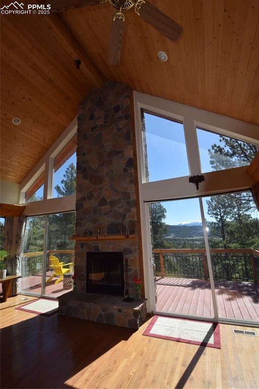 78 Powderhorn Ln, Florissant, CO 80816 - unfurnished living room featuring wood ceiling, hardwood / wood-style floors, a ceiling fan, high vaulted ceiling, and a fireplace