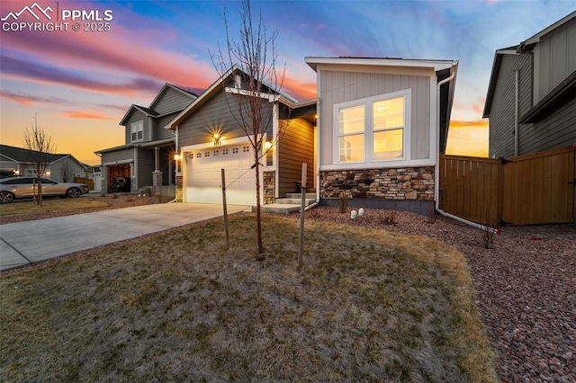 8093 Yellowleaf Pl, Colorado Springs, CO 80908 - view of front of property with fence, concrete driveway, an attached garage, and stone siding
