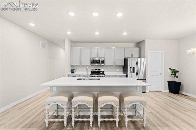 8093 Yellowleaf Pl, Colorado Springs, CO 80908 - kitchen with a kitchen bar, a sink, baseboards, light countertops, and appliances with stainless steel finishes