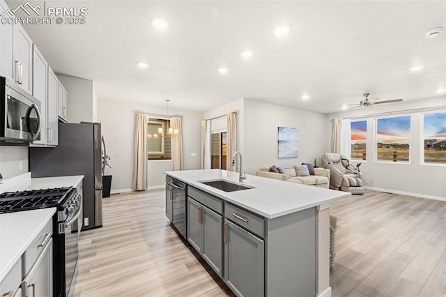 8093 Yellowleaf Pl, Colorado Springs, CO 80908 - kitchen with dishwashing machine, a sink, gas range, stainless steel microwave, and gray cabinetry