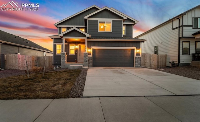 craftsman house with an attached garage, stone siding, fence, concrete driveway, and board and batten siding