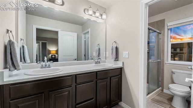 full bathroom featuring toilet, a sink, and a stall shower