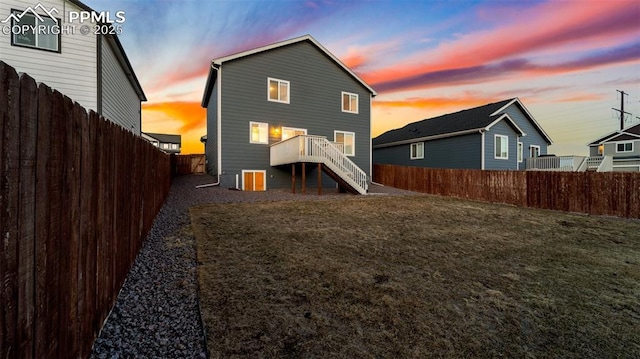 back of house with a yard, stairway, and a fenced backyard