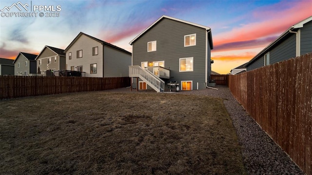back of house with a lawn, stairway, and a fenced backyard
