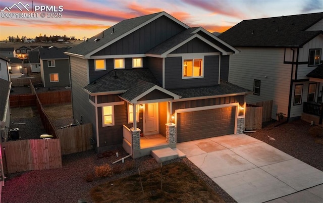 view of front of property with fence, an attached garage, driveway, board and batten siding, and a shingled roof