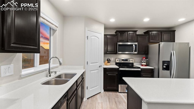 kitchen with recessed lighting, light countertops, appliances with stainless steel finishes, and a sink