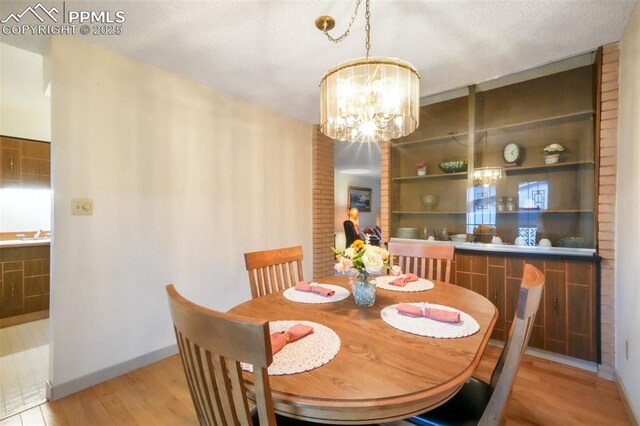 3314 Valley Hi Ave Unit B, Colorado Springs, CO 80910 - dining area featuring a chandelier, light wood finished floors, and baseboards