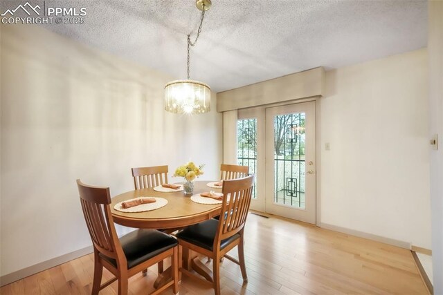 3314 Valley Hi Ave Unit B, Colorado Springs, CO 80910 - dining room featuring a chandelier, a textured ceiling, wood finished floors, and baseboards