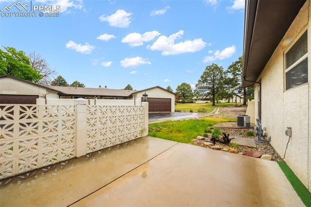 3314 Valley Hi Ave Unit B, Colorado Springs, CO 80910 - view of patio with a detached garage, fence, and cooling unit