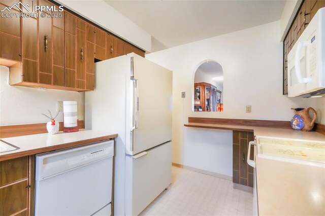 3314 Valley Hi Ave Unit B, Colorado Springs, CO 80910 - kitchen featuring white appliances, light countertops, brown cabinetry, and light floors