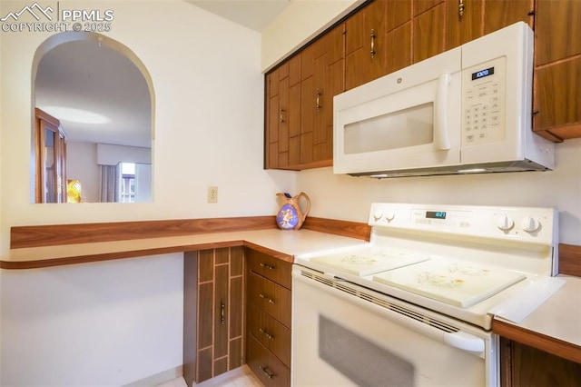 3314 Valley Hi Ave Unit B, Colorado Springs, CO 80910 - kitchen with white appliances, brown cabinetry, light countertops, and arched walkways