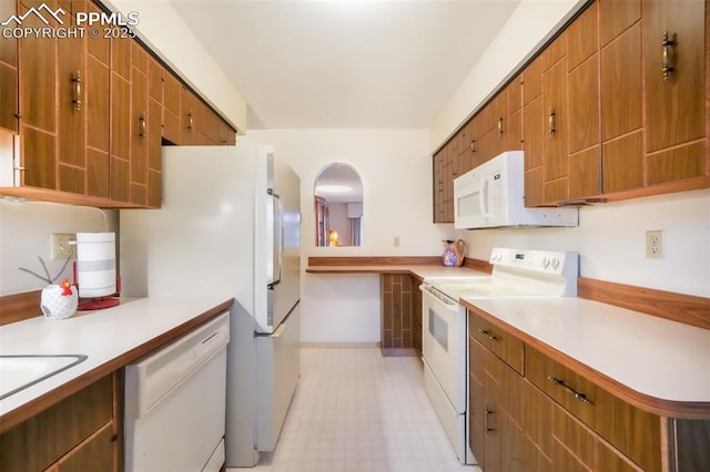 3314 Valley Hi Ave Unit B, Colorado Springs, CO 80910 - kitchen with white appliances, light countertops, arched walkways, and brown cabinets