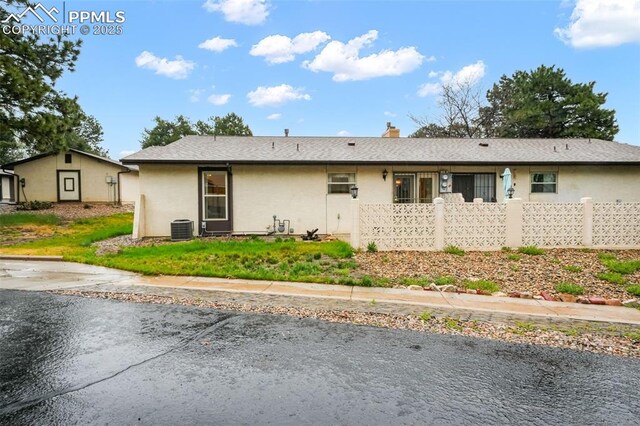 3314 Valley Hi Ave Unit B, Colorado Springs, CO 80910 - view of front of home featuring central AC unit, fence, a chimney, and stucco siding