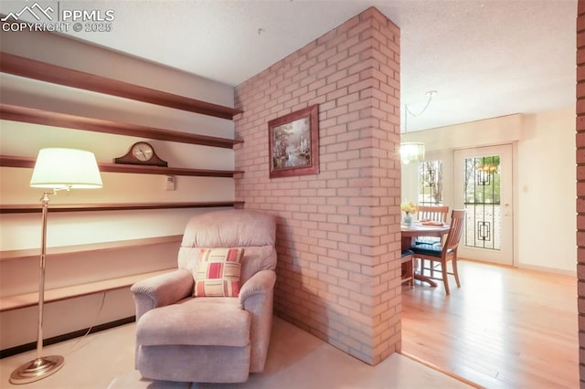 3314 Valley Hi Ave Unit B, Colorado Springs, CO 80910 - sitting room with brick wall, wood finished floors, and a textured ceiling