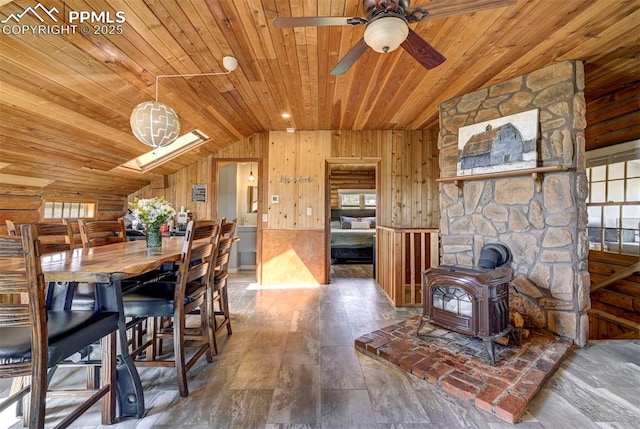 3645 Doolittle Rd, Monument, CO 80132 - dining room featuring a wood stove, lofted ceiling, wooden ceiling, wood walls, and plenty of natural light