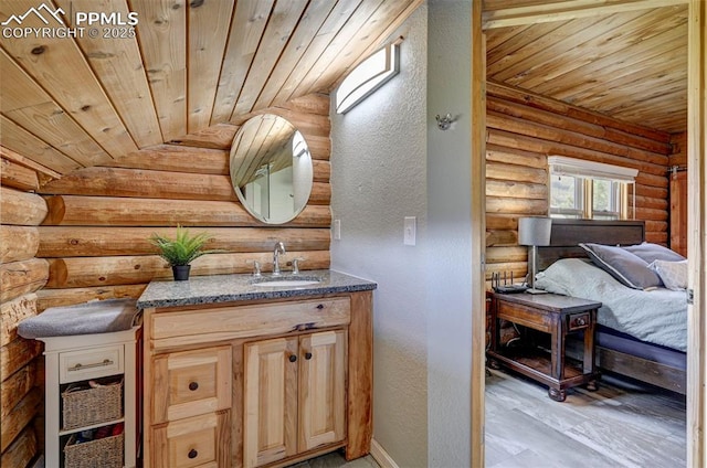 3645 Doolittle Rd, Monument, CO 80132 - bathroom featuring wood ceiling, log walls, vanity, a textured wall, and baseboards