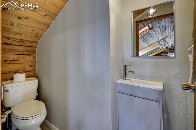 3645 Doolittle Rd, Monument, CO 80132 - bathroom featuring vaulted ceiling, toilet, vanity, wooden ceiling, and a textured wall