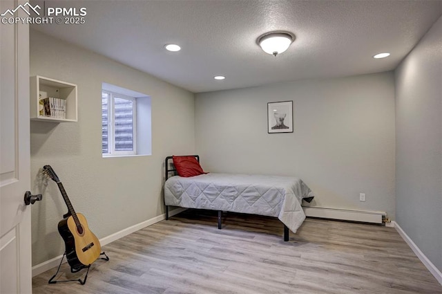 3645 Doolittle Rd, Monument, CO 80132 - bedroom featuring wood finished floors, recessed lighting, baseboards, a textured ceiling, and baseboard heating