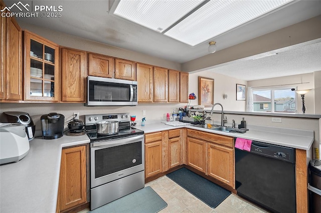 7136 Purple Thistle Ct, Colorado Springs, CO 80922 - kitchen featuring stainless steel appliances, a sink, light countertops, and glass insert cabinets