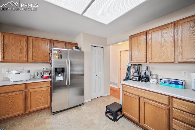 7136 Purple Thistle Ct, Colorado Springs, CO 80922 - kitchen featuring stainless steel fridge with ice dispenser, light countertops, and brown cabinetry