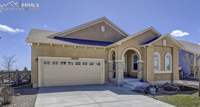 view of front of house with stucco siding, concrete driveway, a garage, and fence