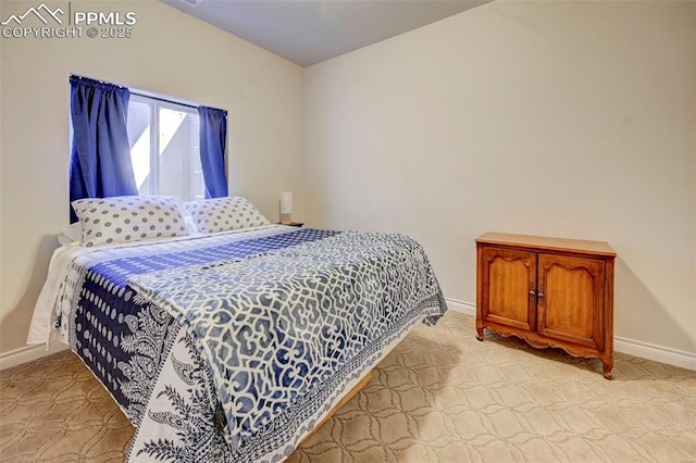 bedroom with baseboards and light colored carpet