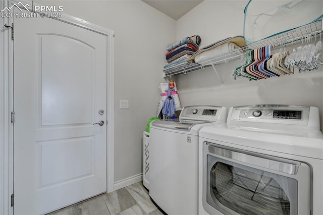 washroom with separate washer and dryer and baseboards