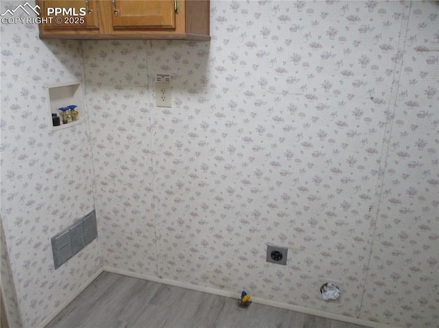 laundry area with cabinet space, wood finished floors, hookup for a washing machine, hookup for an electric dryer, and baseboards