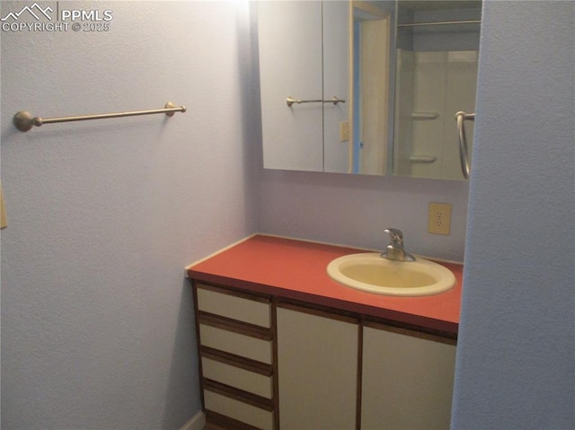 bathroom featuring vanity and a textured wall