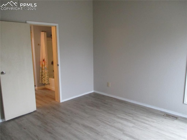 spare room featuring wood finished floors and baseboards