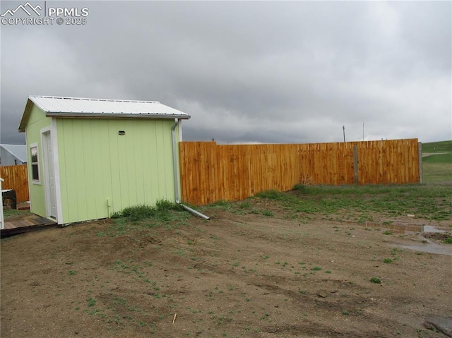 view of yard with fence and an outbuilding