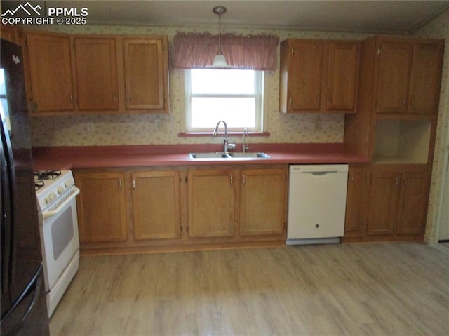 kitchen featuring white appliances, a sink, wallpapered walls, brown cabinets, and light wood-type flooring