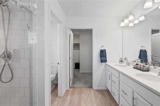 16422 Mountain Flax Dr, Monument, CO 80132 - bathroom featuring wood finished floors, double vanity, and tiled shower