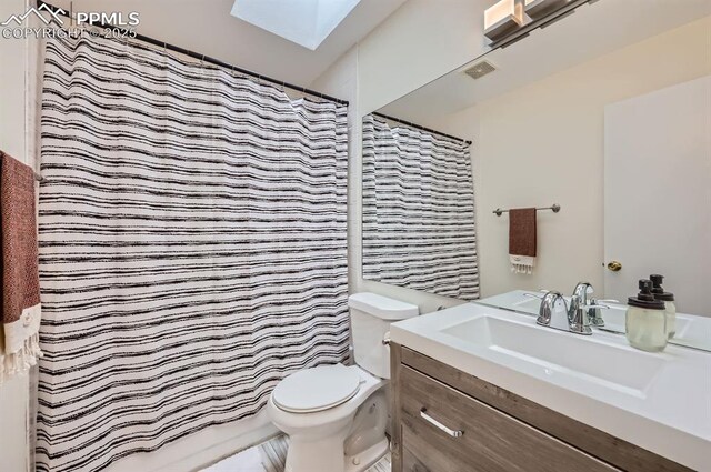 4258 Grassy Ct, Colorado Springs, CO 80916 - bathroom featuring a skylight, toilet, vanity, and curtained shower