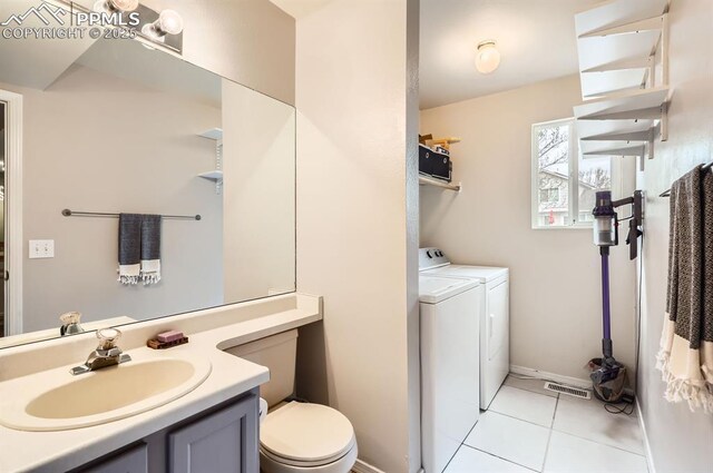 4258 Grassy Ct, Colorado Springs, CO 80916 - bathroom featuring washer and clothes dryer, toilet, tile patterned flooring, vanity, and baseboards