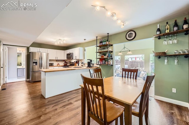 4258 Grassy Ct, Colorado Springs, CO 80916 - dining space featuring dark wood-style flooring, baseboards, and track lighting