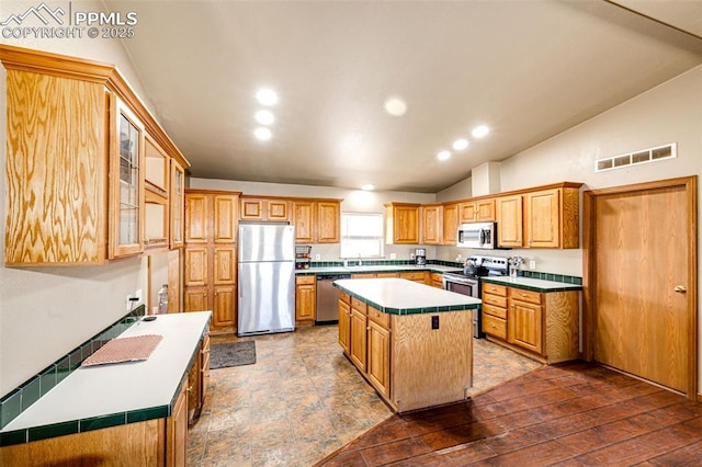 26985 Flower Cir, Simla, CO 80835 - kitchen featuring appliances with stainless steel finishes, a kitchen island, lofted ceiling, light countertops, and a sink