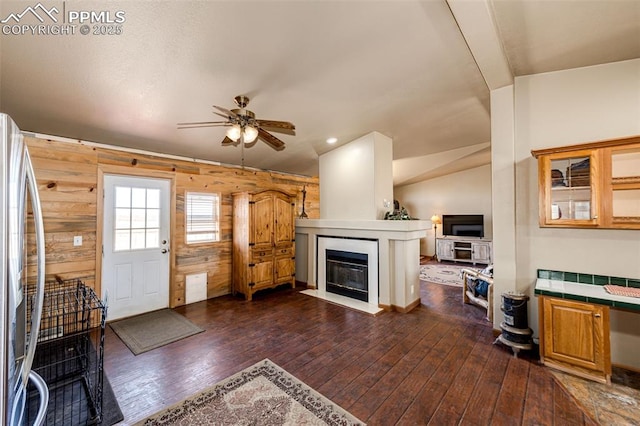 26985 Flower Cir, Simla, CO 80835 - living area with a fireplace with flush hearth, a ceiling fan, dark wood finished floors, wood walls, and recessed lighting