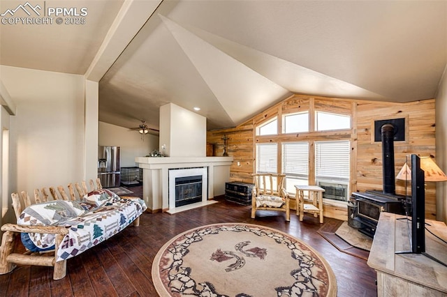 26985 Flower Cir, Simla, CO 80835 - living area with wooden walls, vaulted ceiling, a wood stove, hardwood / wood-style floors, and ceiling fan
