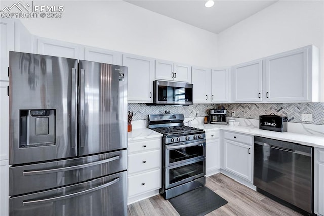6244 Roundup Butte St, Colorado Springs, CO 80925 - kitchen featuring stainless steel appliances, backsplash, light wood-type flooring, light stone countertops, and white cabinetry